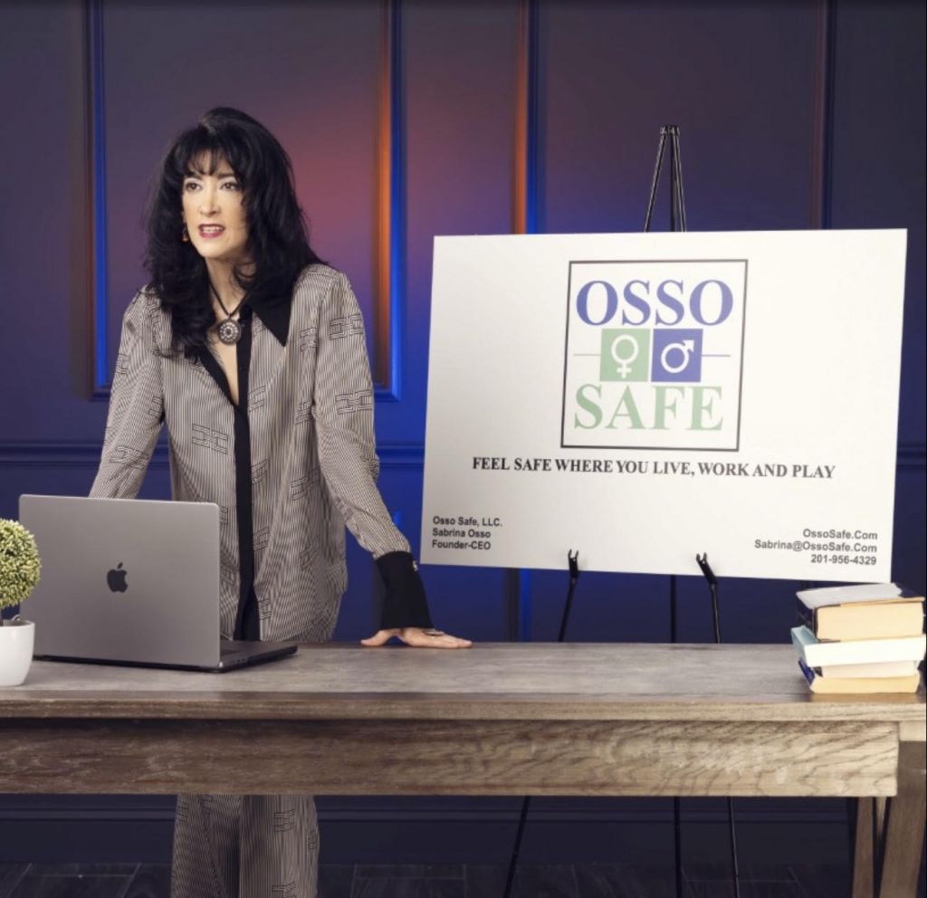 OSSO Safe - Owner wearing a suit standing at a table with a laptop doing a presentation