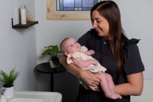 Julie from Gold Coast Doulas holding an infant in a bathroom