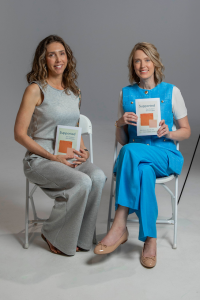 Alyssa Veneklese and Kristin Revere sitting holding copies of their book Supported